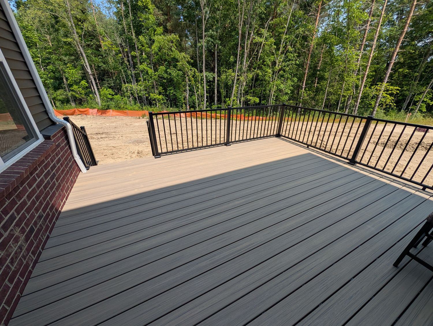 Trex deck with pergola and outdoor dining area built by Supreme Deck Builders in South Lyon, Michigan