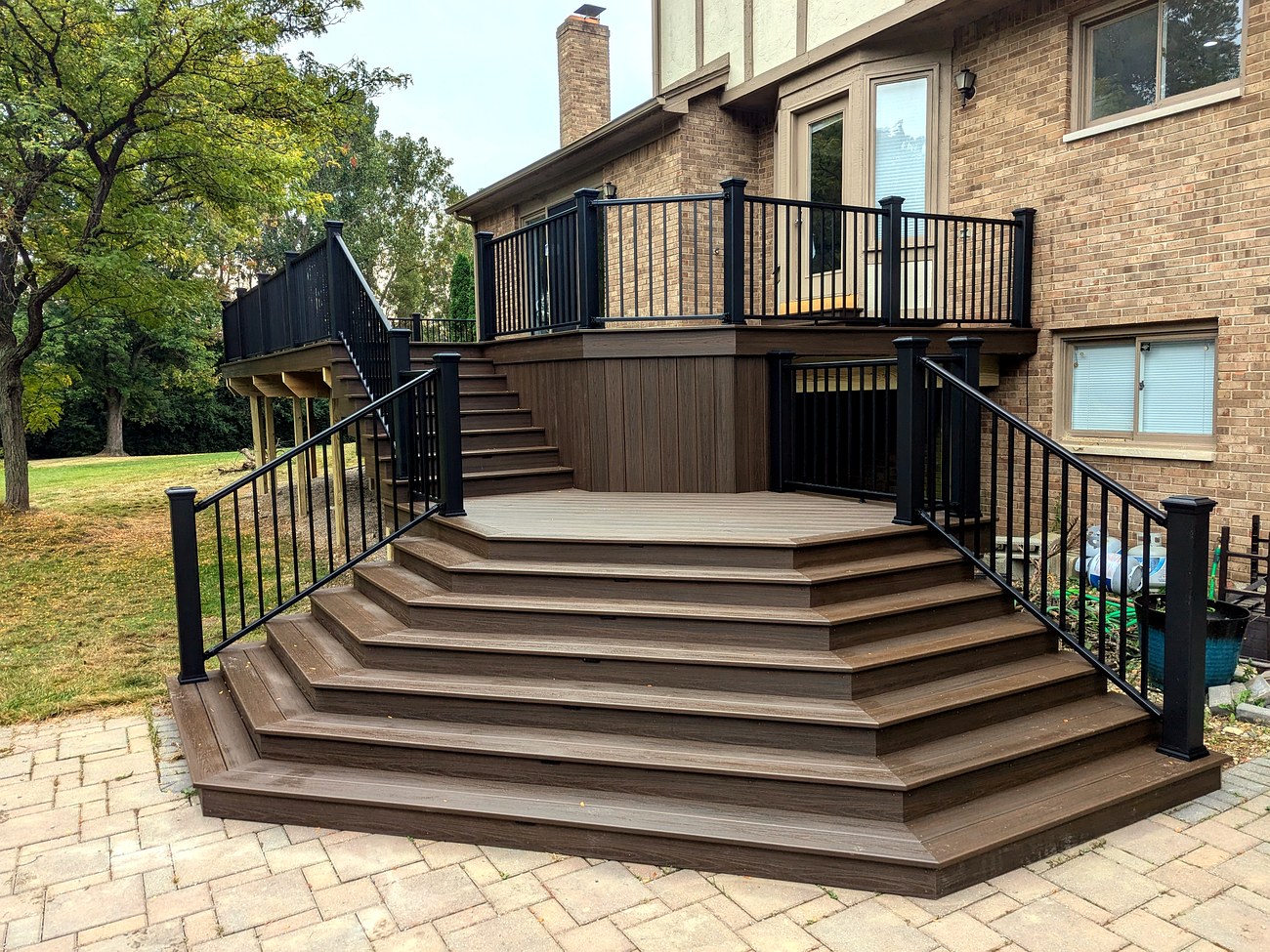 Multi-level octagon Trex composite deck with a custom curved staircase and black aluminum railing